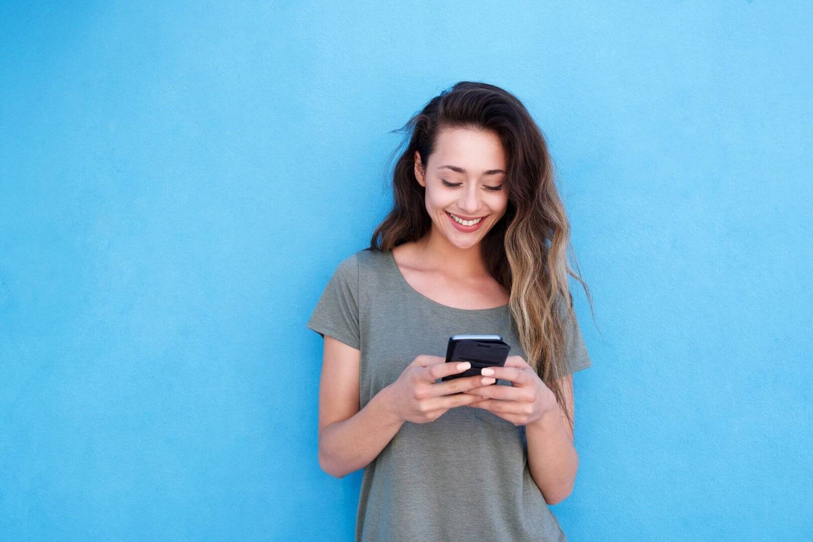 woman smiling down at her phone